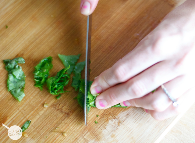 A process shot of chopping basil to make an easy bruschetta bar