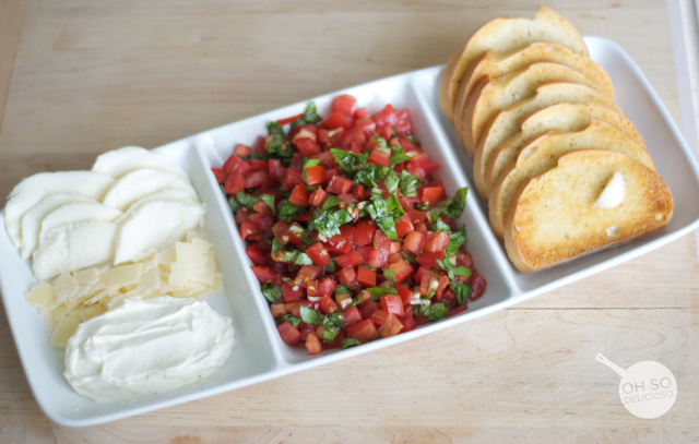 A plate filled with tomatoes, mozzarella and bread for making an easy bruschetta bar