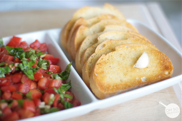 A close up of toasted bread and chopped tomatoes ready for making an easy bruschetta bar