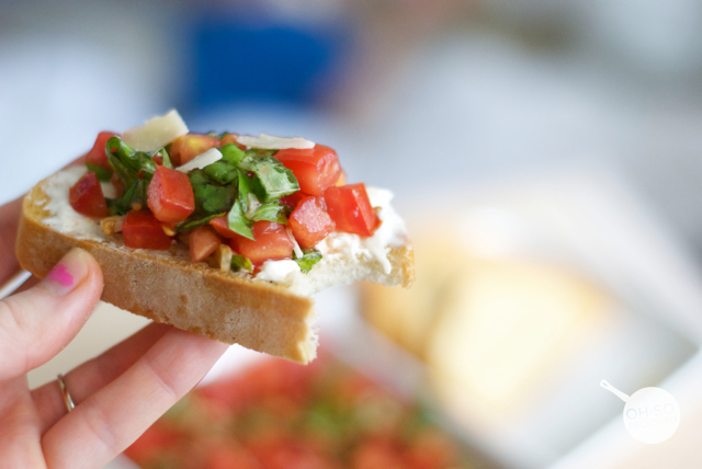 A slice of tomato bruschetta with a bite out