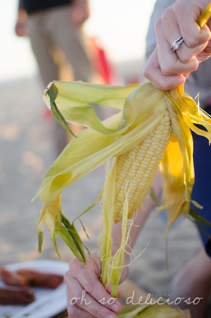 Pulling husks off of corn on the cob